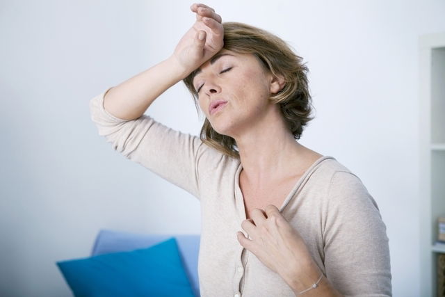 mulher se refrescando com ventilador