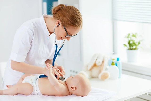 Médico auscultando a un bebé con el virus sincitial respiratorio