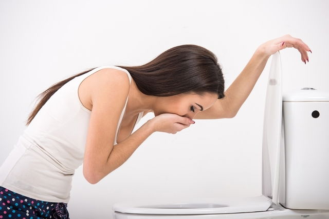 femme assise devant les toilettes qui présente une envie de vomir