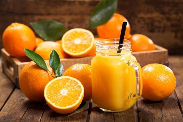Naranjas y jugo de naranja en un frasco