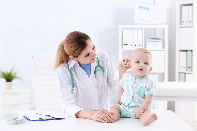 Pediatra examinando ouvido de bebê