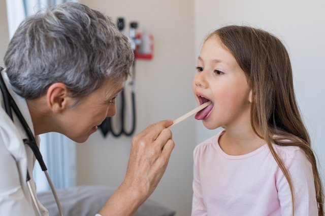 Médica avalia língua de uma menina