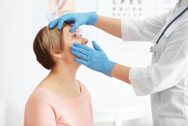 Medico oftalmologista examinando o olho de uma mulher