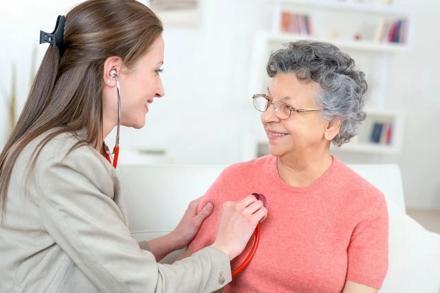 Cardióloga auscultando el corazón de una señora mayor