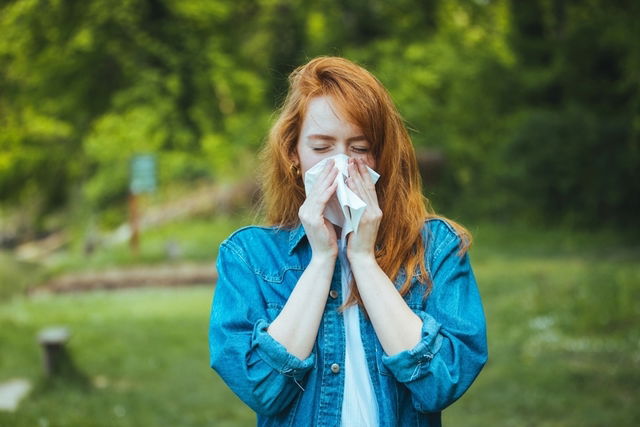 Mujer estornudando limpiándose con un pañuelo