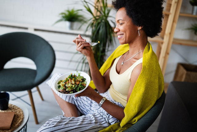 Woman smiling and eating salad