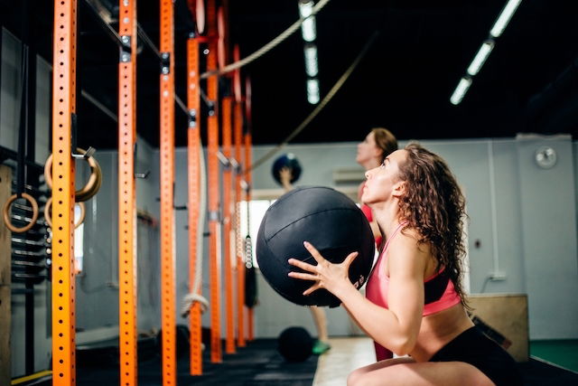 Jovem Mulher Que Faz Flexões De Braço - Exercício Do Crossfit Foto