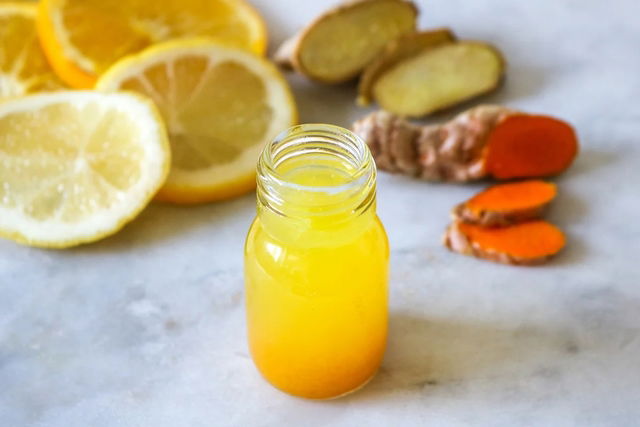 Jugo de naranja, rodajas de limón y jengibre