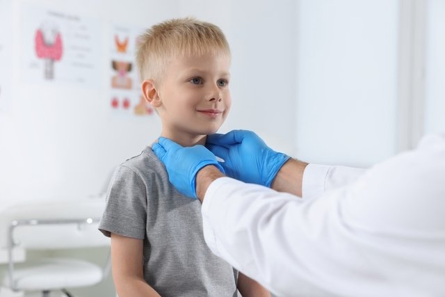 Pediatra examinando la zona del cuello del niño