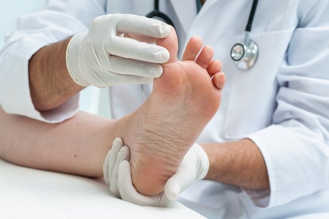 Médico examinando o pé de um paciente