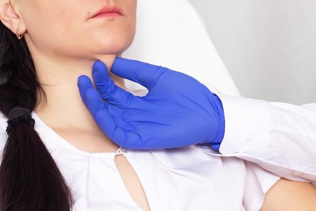 Médico avaliando o pescoço de uma mulher