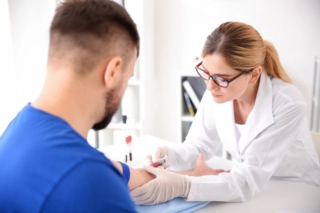 Técnica coletando uma amostra de sangue de um homem para exames 