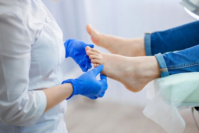 Médico examinando los pies de un paciente